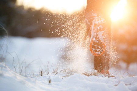 Picture from behind running man in sneakers on snowy forestの写真素材