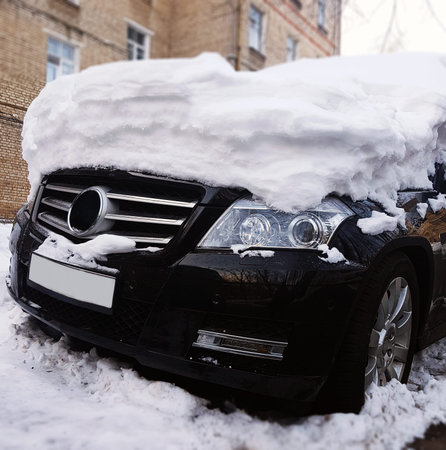 Photo of black car with snow on hood at streetの写真素材