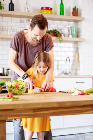 Picture of father with little daughter cooking saladの写真素材