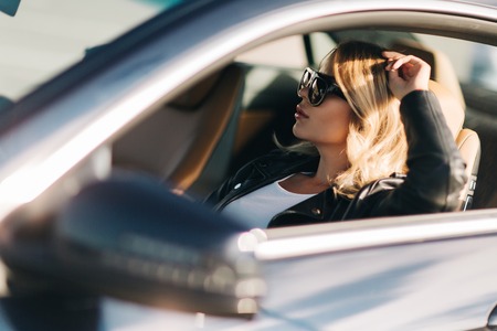 Photo of woman on sunglasses sitting in car.の写真素材