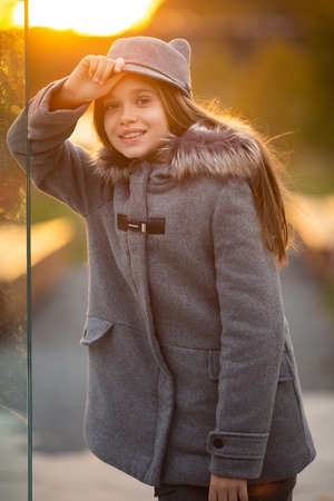 Photo of girl in gray hat and coat on blurred background at cityの写真素材