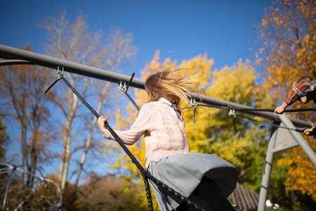 Photo of girl swinging in autumn parkの写真素材