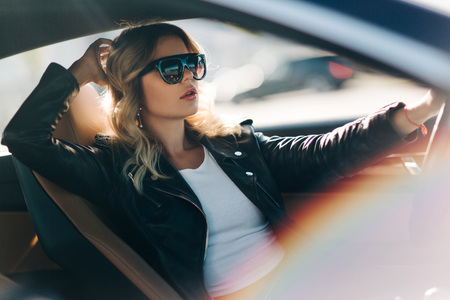 Photo of blonde behind wheel in car.の写真素材