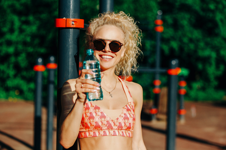 Photo of sports woman wearing sunglasses with bottle of water neの写真素材