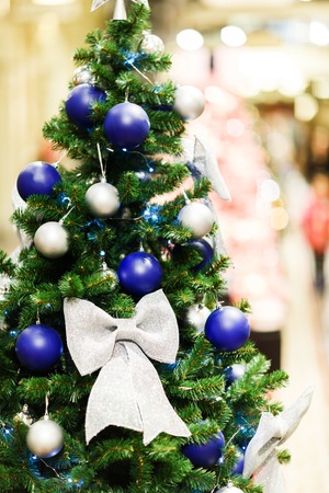 Photo of decorated Christmas spruce with white and blue balls in storeの写真素材