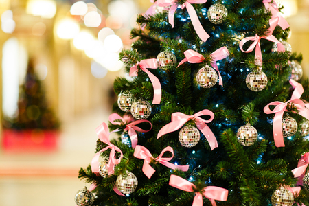 Picture of Christmas tree with balls with sequins, pink bows on blurred backgroundの写真素材
