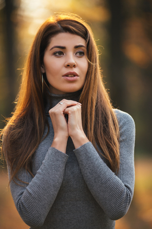 Portrait of long-haired girl in autumn park in afternoon.の写真素材