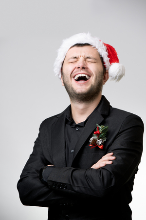 Photo of happy brunet in santa cap with arms crossedの写真素材