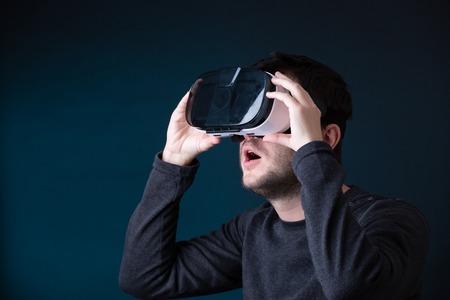 Photo of surprised young man in virtual reality glassesの写真素材