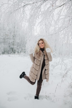 Image of happy blonde woman on walk in winter forestの写真素材