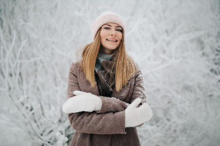Portrait of smiling woman in hat on walk in winter forestの写真素材