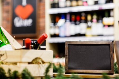 Picture of empty plate on background of racks with bottles of wineの写真素材