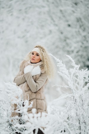 Portrait of blonde woman on walk in winter forestの写真素材