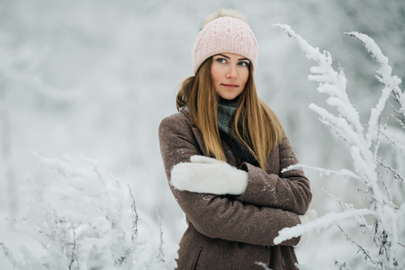 Portrait of smiling woman in hat on walk in winter forestの写真素材