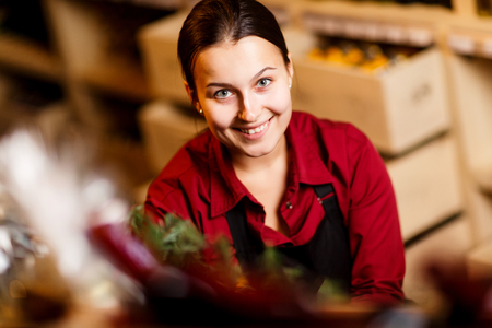Photo of young woman with bottle in hands in wine shopの写真素材
