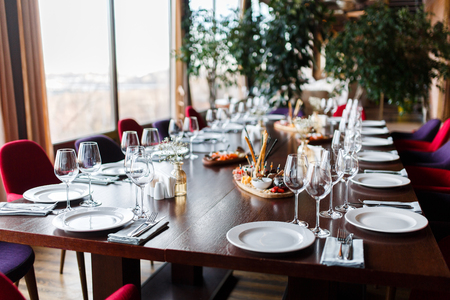 Photo of table with empty plates, forks, knives in restaurant.の写真素材