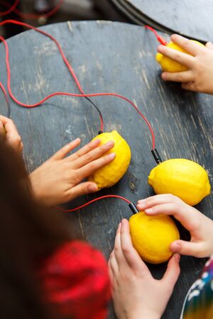 Picture of lemons with red wires on a black wooden tableの写真素材