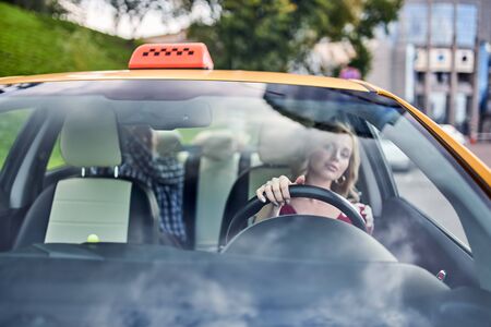 Photo through windshield of female driver on blurry backgroundの写真素材