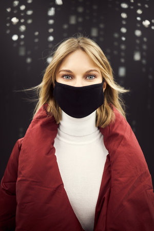 Woman in mask and red coat in the subway