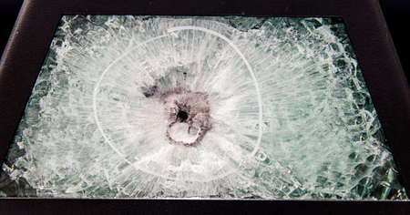broken glass. Car glass cracked from an accident. Armored glass after impact. glass reinforced with a film after being hit by a bullet.の写真素材