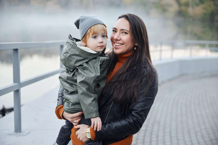 beautiful woman with a baby in her arms. in the parkの写真素材