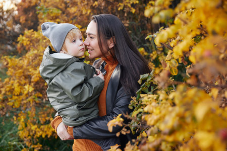 beautiful woman with a baby in her arms. in the parkの写真素材