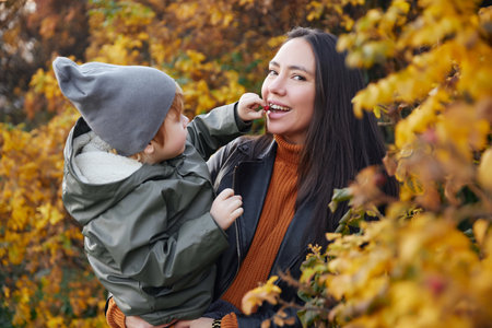 beautiful woman with a baby in her arms. in the parkの写真素材