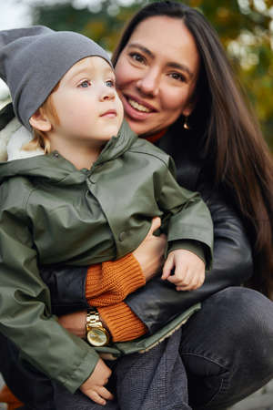 beautiful woman hugs her son in the parkの写真素材
