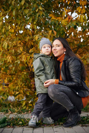 beautiful woman hugs her son in the parkの写真素材