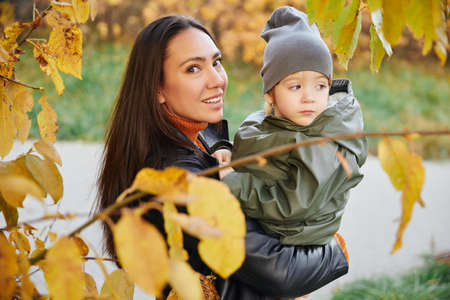 beautiful woman with a baby in her arms. in the parkの写真素材
