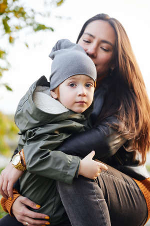 beautiful woman with a baby in her arms. in the parkの写真素材