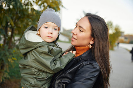 beautiful woman with a baby in her arms. in the parkの写真素材