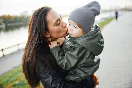 beautiful woman with a baby in her arms. in the parkの写真素材