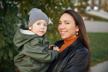 beautiful woman with a baby in her arms. in the parkの写真素材