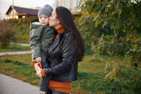 beautiful woman with a baby in her arms. in the parkの写真素材