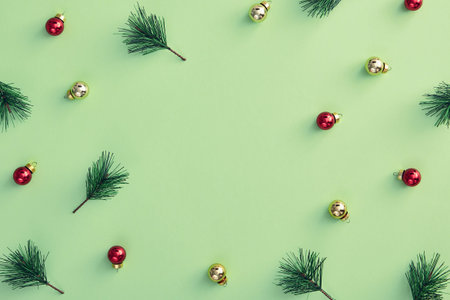 Christmas minimal concept - pattern with christmas balls and pine branch on pastel green background....