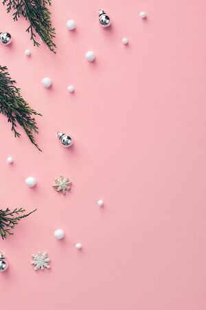 Christmas minimal concept - composition with christmas bauble, tree branch and snowball on pink background. Modern hipster mockup on pink backdrop. Snowfall background. Xmas winter holiday concept.の写真素材