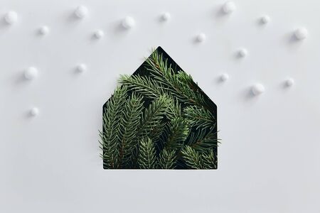Christmas minimal concept - simple house silhouette made of christmas tree branch with snowfall. Flat lat, top view. Vintage rustic mockup with green tree pine house. Winter background. Christmas snowの写真素材