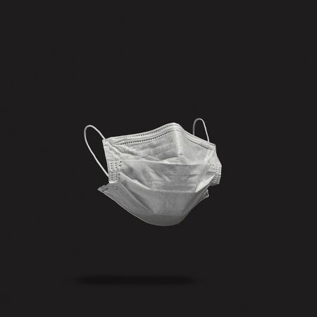 Surgical face mask on dark background. Minimal medical concept. Medical equipmentの写真素材