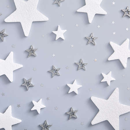 Christmas minimal pattern - monochrome layout with white and silver star. Square composition, flat lay, top view. Vintage holiday decor.の写真素材