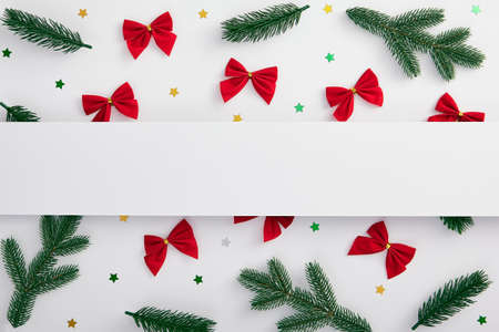 Christmas minimal concept - Christmas tree branch, confetti star and red bow decoration on white background. Horizontal template. White paper blank, flat lay. Banner background. Christmas composition.の写真素材