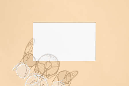 White chair and round table on beige background top view. White empty paper blank in sunshine with hard shadow. Cafe, restaurant, summer, dining concept.の写真素材