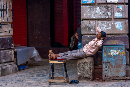 MUMBAI, INDIA - DECEMBER 12, 2014 : A man relaxing at the street of Mumbaiのeditorial素材