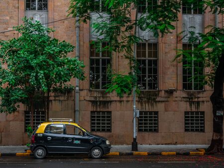 MUMBAI, INDIA - JUNE 24, 2018 : A famous black & yellow collored taxi standing in parking at the streets of Ballard Estate, Mumbaiのeditorial素材