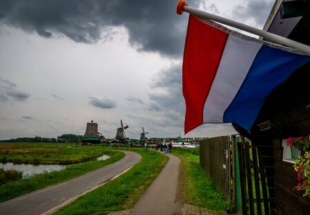 Zaanse Schans, Holland - August 26, 2018 : Holland flag flying near Traditional Dutch house in Zaanse Schans. The Zaanse Schans is a typically Dutch small village in Amsterdam, Netherlands.のeditorial素材