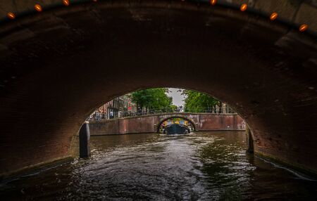 Amsterdam, Netherlands - August 26, 2018: Cityscape of Amsterdam with Canal, boat, and traditional bridgeのeditorial素材