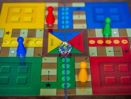 Pieces and a die on a Ludo board gameの写真素材
