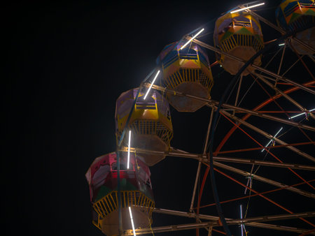 A colourful Giant wheel at amusement park illuminated at night in India