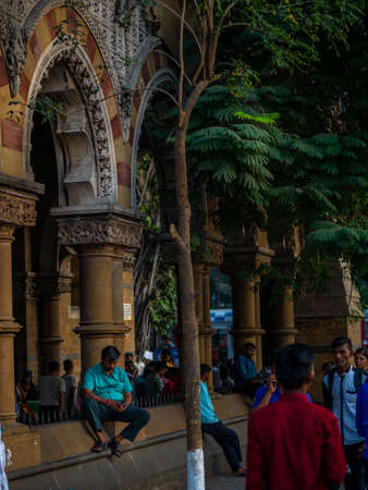 Mumbai, India - January 26, 2020 : Unidentified indian man watching mobile phone on a busy street near CST stationのeditorial素材
