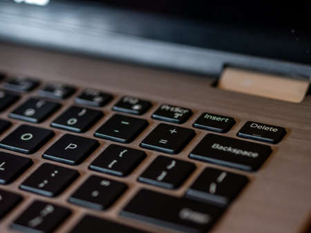 Closeup of laptop keyboard, Black keys on silver laptop. Delete key in focus.の写真素材